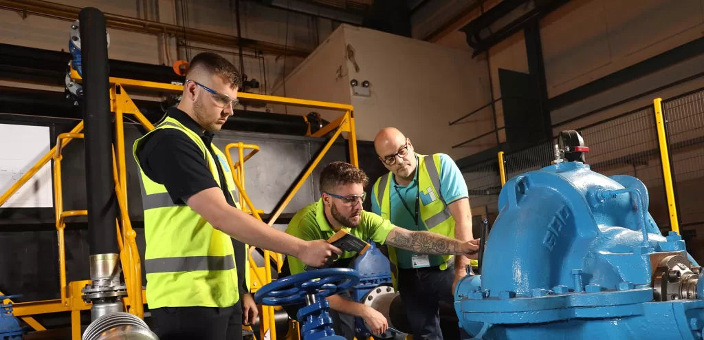 Technician testing liquid pump performance in an industrial fluid handling system to ensure optimal flow and pressure levels